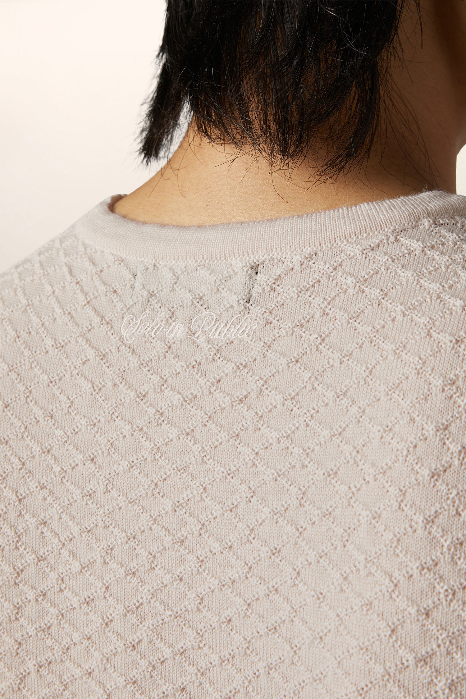 Close-up of textured Italian merino wool fabric used in luxury sleeveless vest — premium contemporary menswear knit detail.